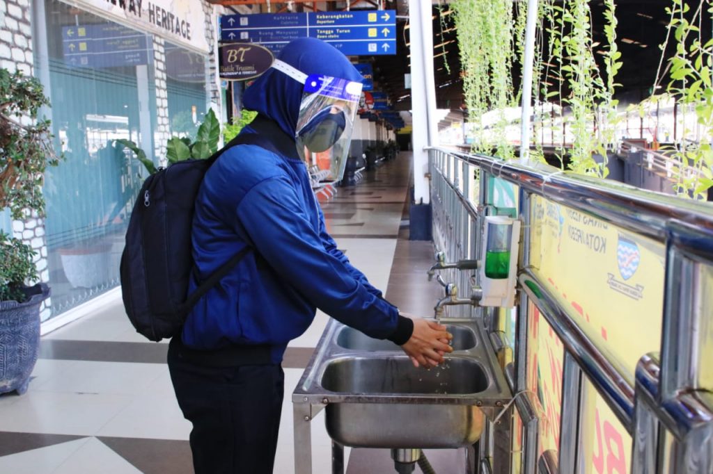 Calon penumpang menggunakan fasilitas cuci tangan yang tersedia di beberapa titik di stasiun