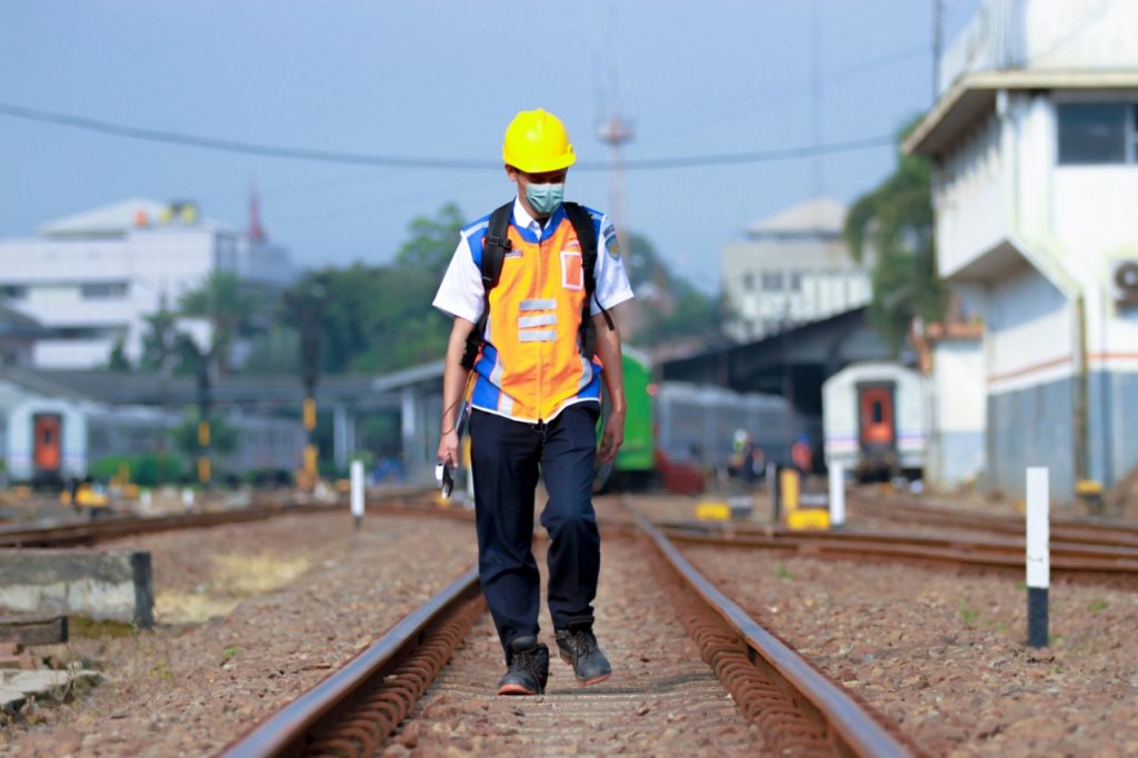 Petugas Pemeriksa Jalur (PPJ) menyusuri rel untuk memastikan jalur yang hendak dilalui kereta api aman.